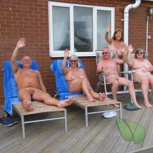 a couple naturists posing in their house in the wilderness
