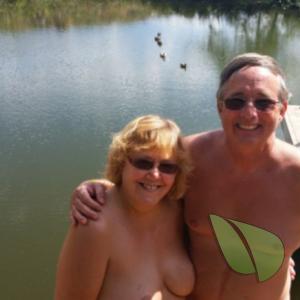 A nudist couple splashing around in the woods