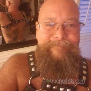 A nudist showing off their tats at their house
