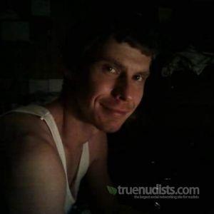 A nudist sitting at home