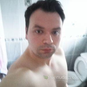 A nudist posing in their house