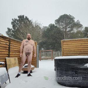 A nudist rocking tattoos outside