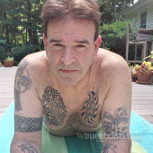 One nudist all tattooed up outdoors