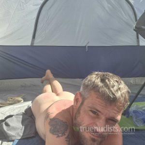 One nudist rocking tattoos camping